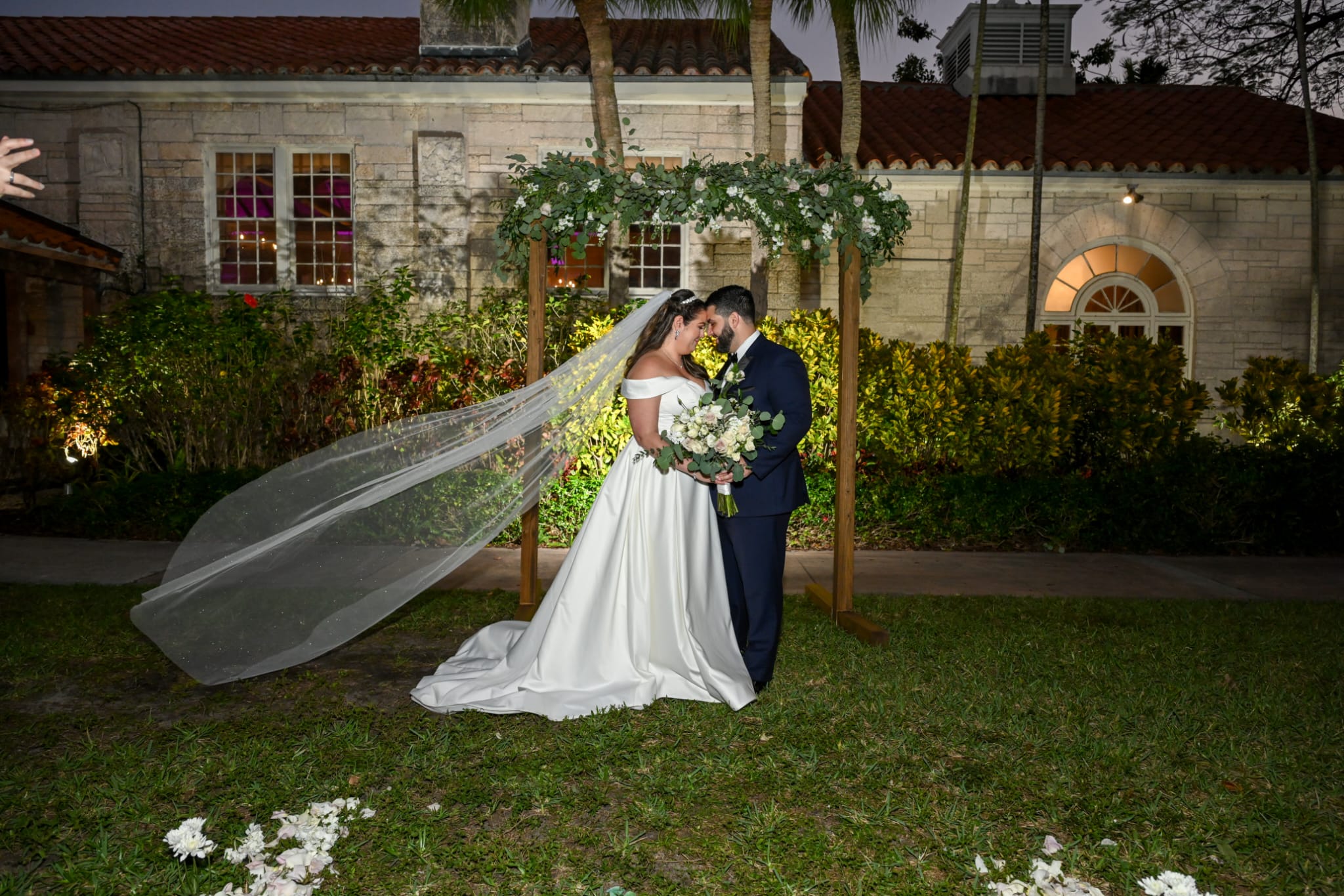 bride and groom under arch