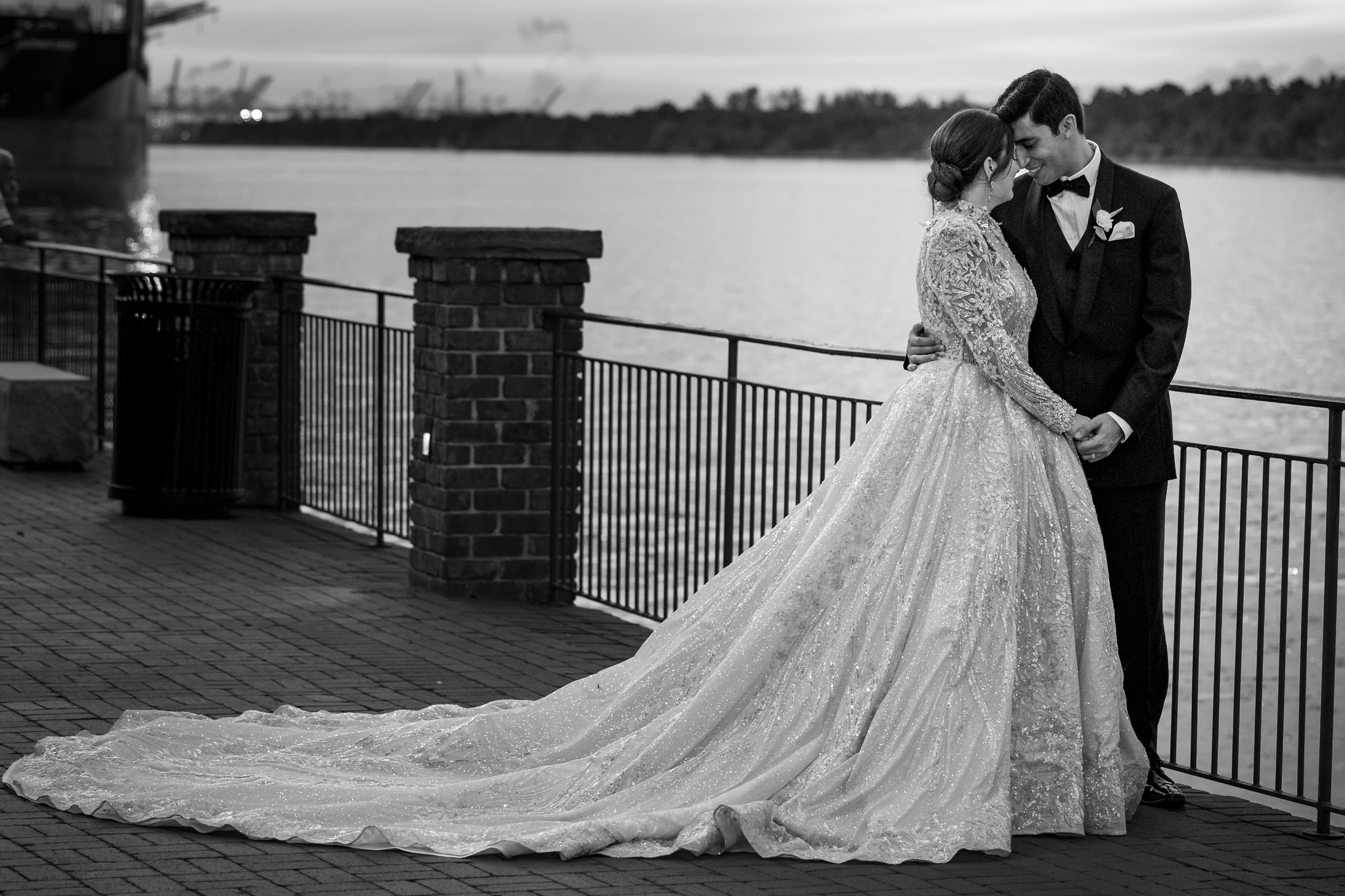 bride and groom embracing next to lake