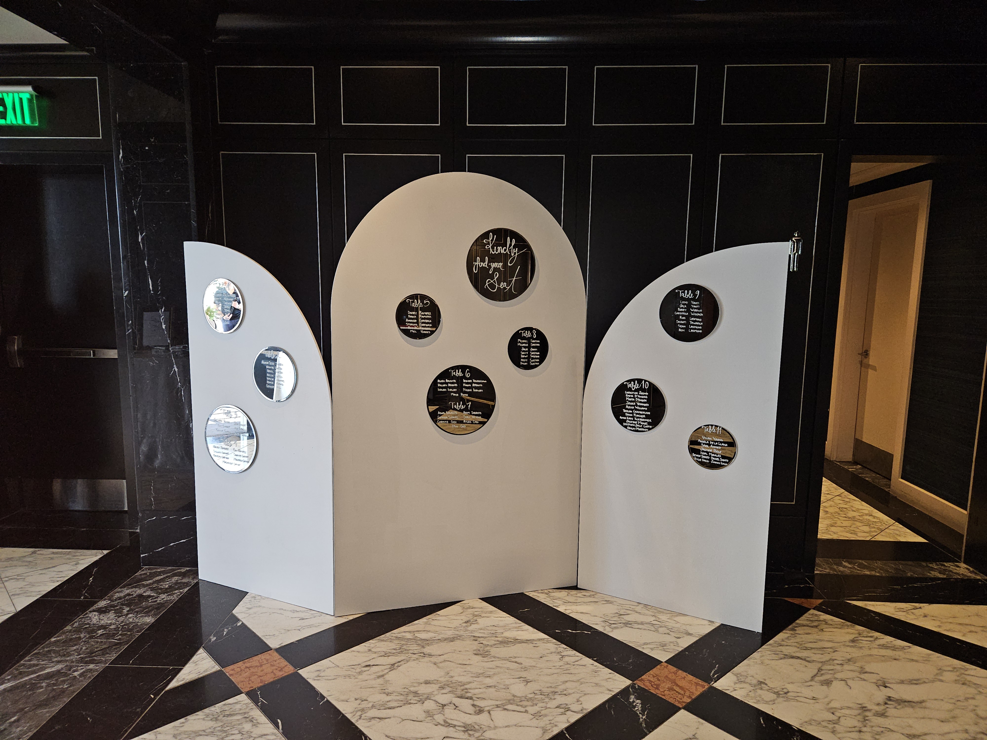 tri-fold wedding backdrop with seat assignments listed