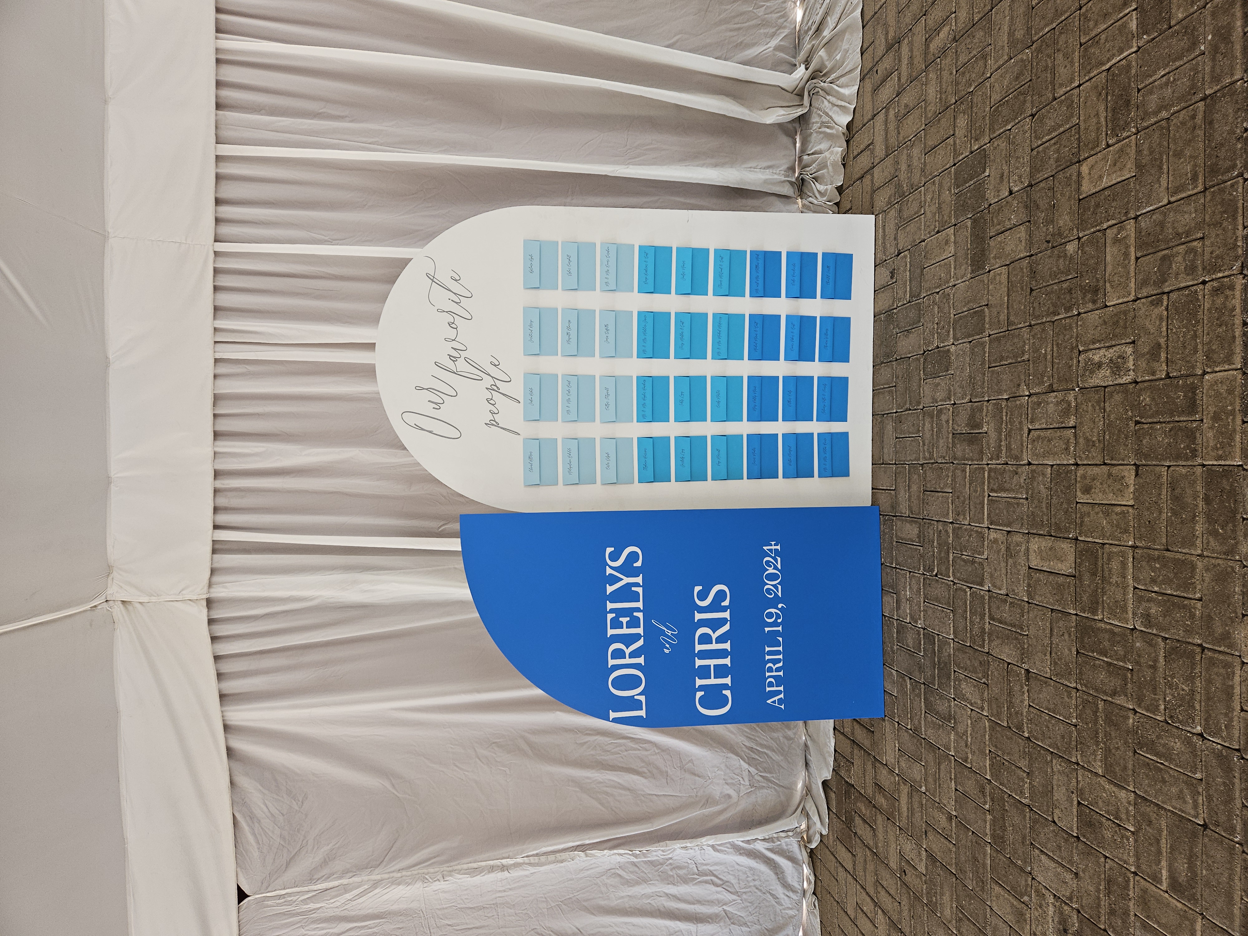 sitting arrangements posted in envelopes on large wooden sign