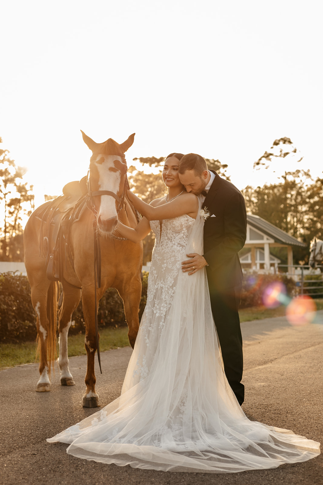 groom embracing bride near a horse 