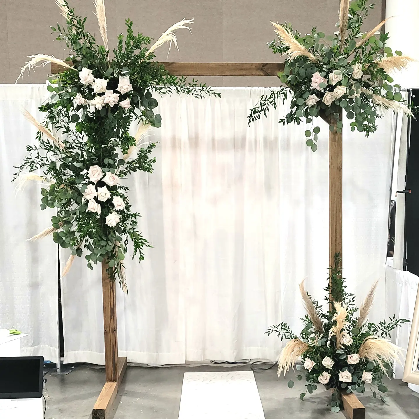 wedding arch with a lot of greenery and white flowers